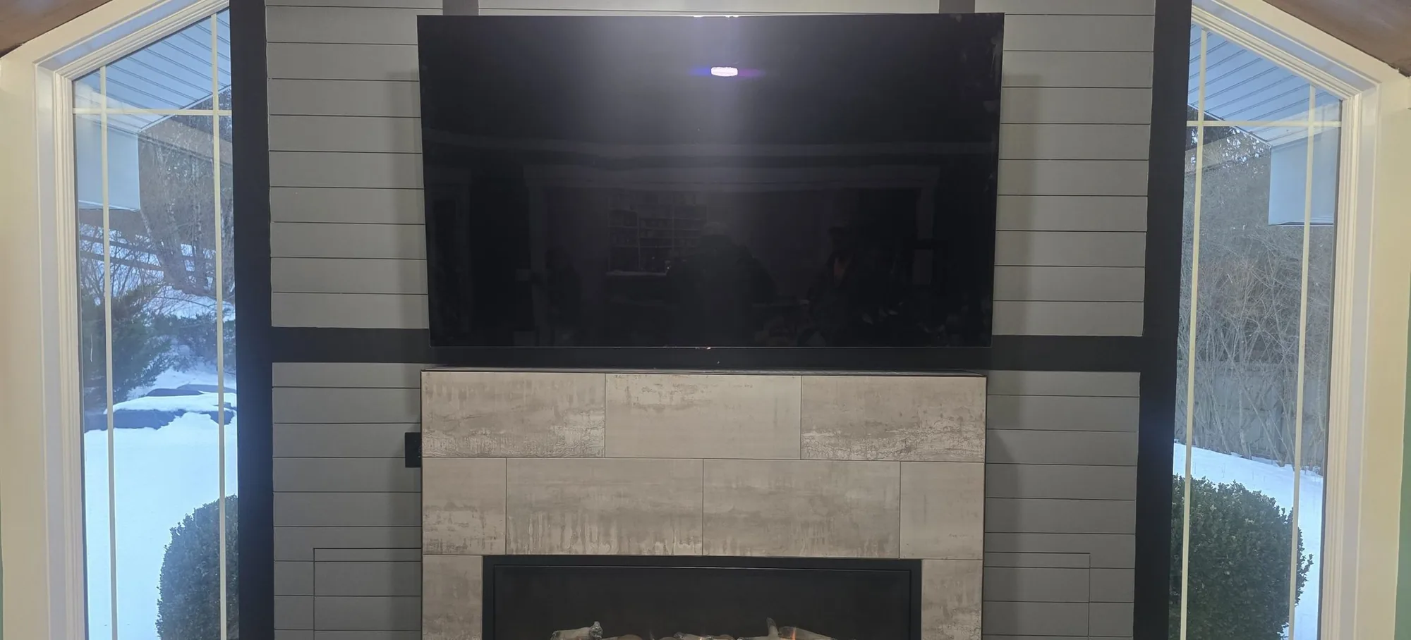 Shiplap fireplace wall with a linear fireplace and a wall-mounted television