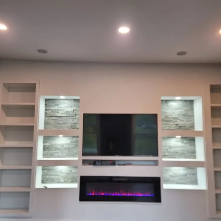 Built-in wall unit with lit stone niches and a linear fireplace