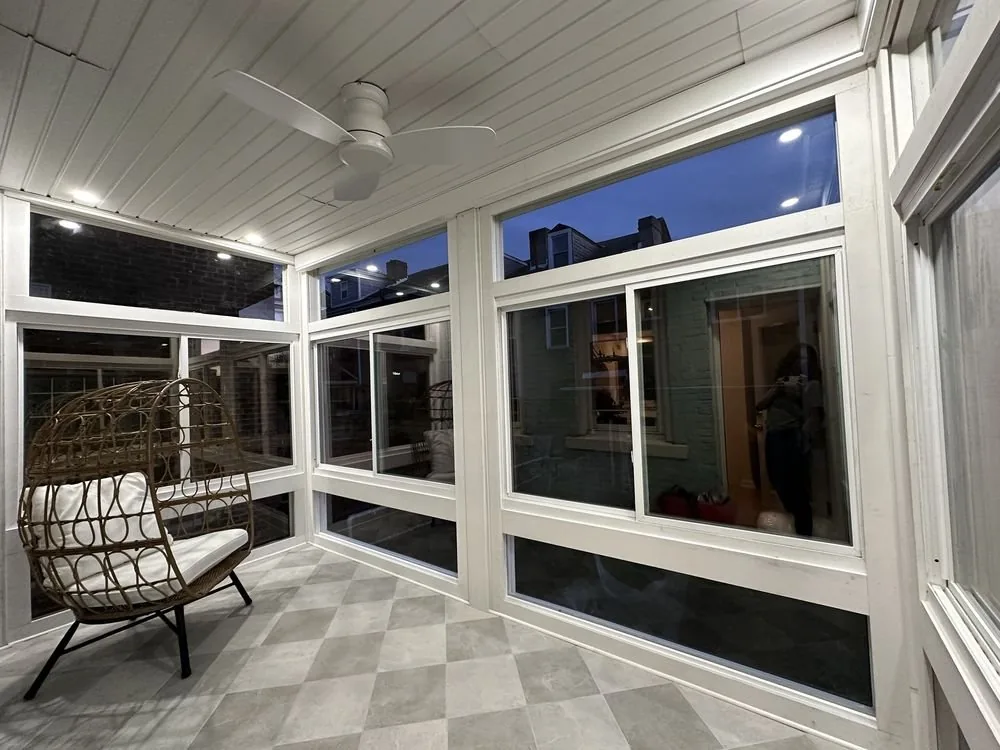 Enclosed porch at dusk with a finished ceiling, ceiling fan, and tile floor